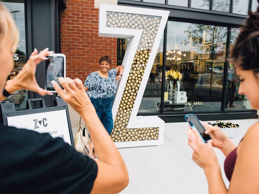 Lady poses in front of Big Z at Z Gallerie event