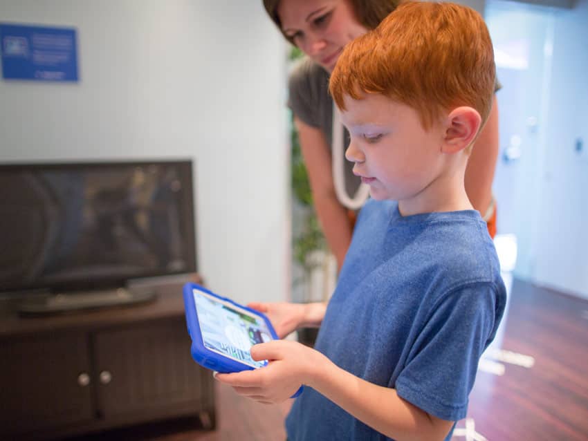 Young boy reviewing Nationwide Insurance safety content on tablet device
